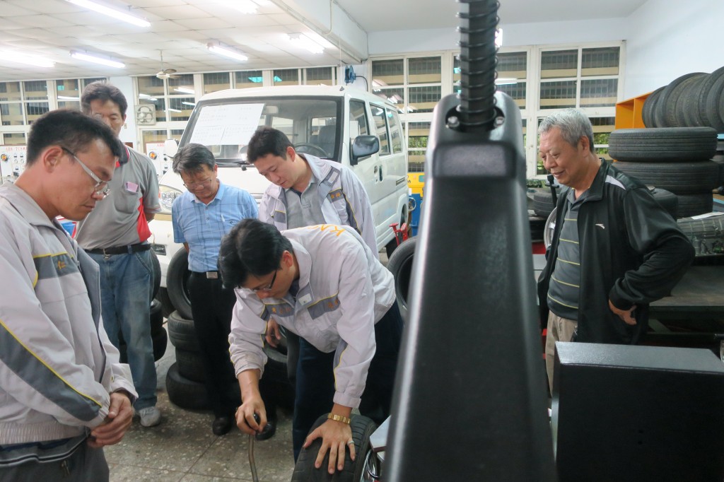 業師示範操作汽車拆胎機